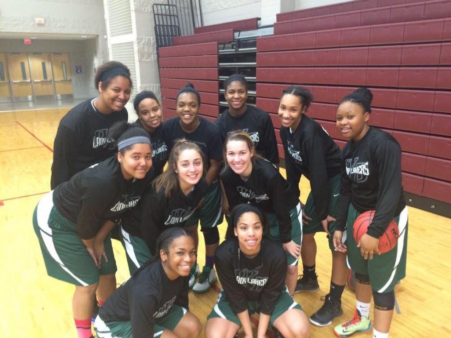 The Varsity Girls Basketball team posing before a game.