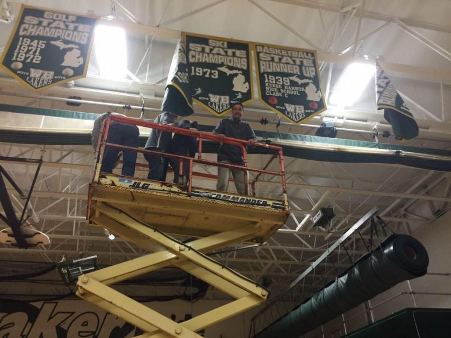The WBHS Administration hangs the Cheer teams banner for their 1st place prize at districts.
