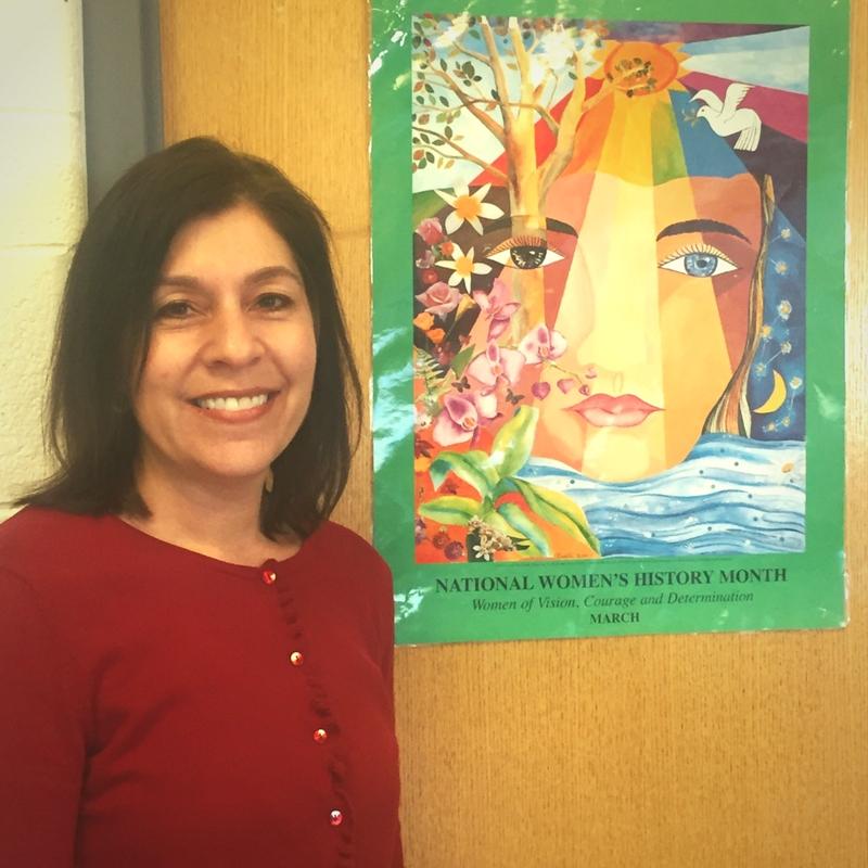 WBHS Social Studies and Leadership teacher Ms. Jennifer Sepetys wears red in support of International Womens Day, alongside her Womens Month poster. 